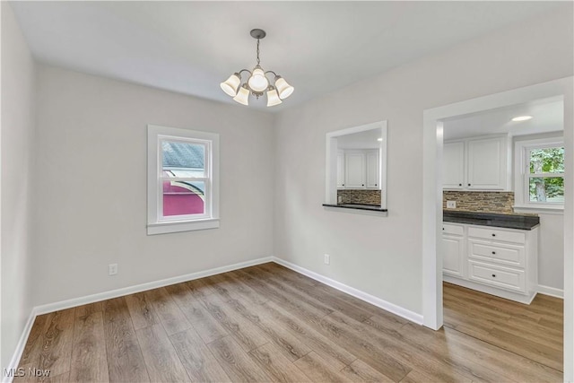 259 Marion Dr, Bedford, OH 44146 - unfurnished dining area with a chandelier and light wood-type flooring