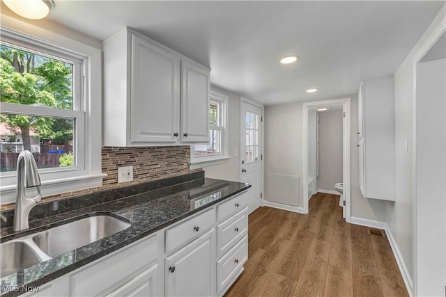 259 Marion Dr, Bedford, OH 44146 - kitchen with white cabinetry, recessed lighting, wood finished floors, decorative backsplash, and dark stone countertops