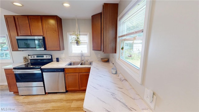 409 W Grant St, Kent, OH 44240 - kitchen featuring appliances with stainless steel finishes, brown cabinets, healthy amount of natural light, recessed lighting, and light wood-style floors