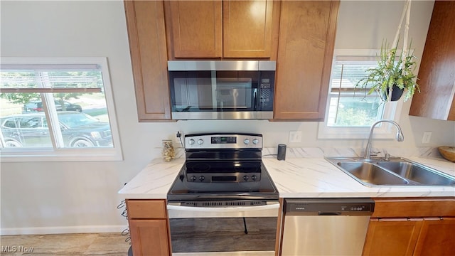 409 W Grant St, Kent, OH 44240 - kitchen with appliances with stainless steel finishes, light stone counters, and brown cabinetry