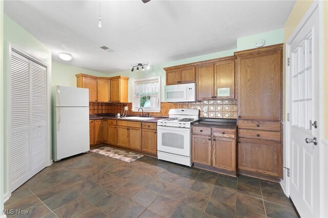 293 W 14th St, Salem, OH 44460 - kitchen with white appliances, dark countertops, tasteful backsplash, and brown cabinets