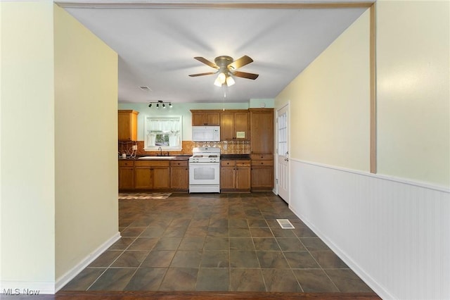 293 W 14th St, Salem, OH 44460 - kitchen featuring white appliances, decorative backsplash, a ceiling fan, brown cabinetry, and dark countertops