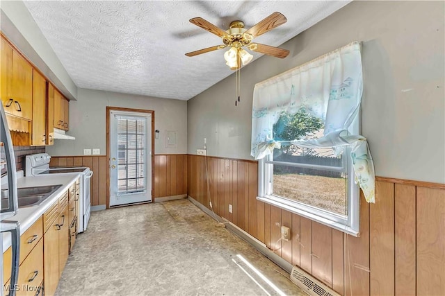 321 Overlook Rd, Vermilion, OH 44089 - kitchen with white range with electric stovetop, a wainscoted wall, under cabinet range hood, plenty of natural light, and light countertops