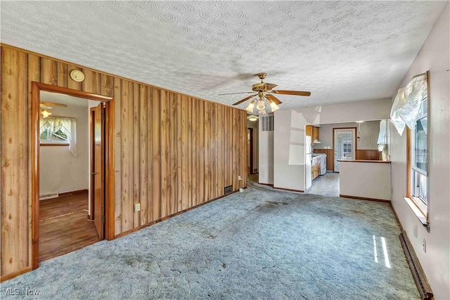 321 Overlook Rd, Vermilion, OH 44089 - unfurnished living room with a ceiling fan, wooden walls, light colored carpet, and a textured ceiling