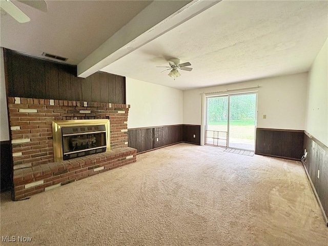 10511 Darrow Rd, Vermilion, OH 44089 - unfurnished living room with a ceiling fan, a wainscoted wall, wooden walls, carpet floors, and a brick fireplace