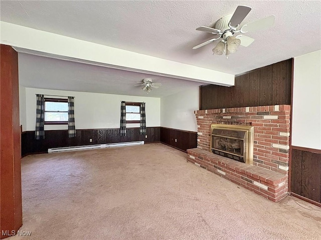 10511 Darrow Rd, Vermilion, OH 44089 - unfurnished living room with a baseboard heating unit, wainscoting, ceiling fan, carpet floors, and wood walls