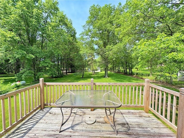 10511 Darrow Rd, Vermilion, OH 44089 - wooden terrace featuring outdoor dining area, a yard, and view of wooded area