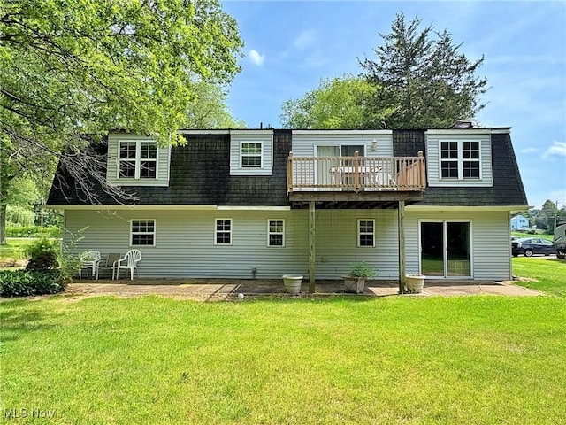 10511 Darrow Rd, Vermilion, OH 44089 - back of house featuring roof with shingles, a lawn, a wooden deck, mansard roof, and a patio area