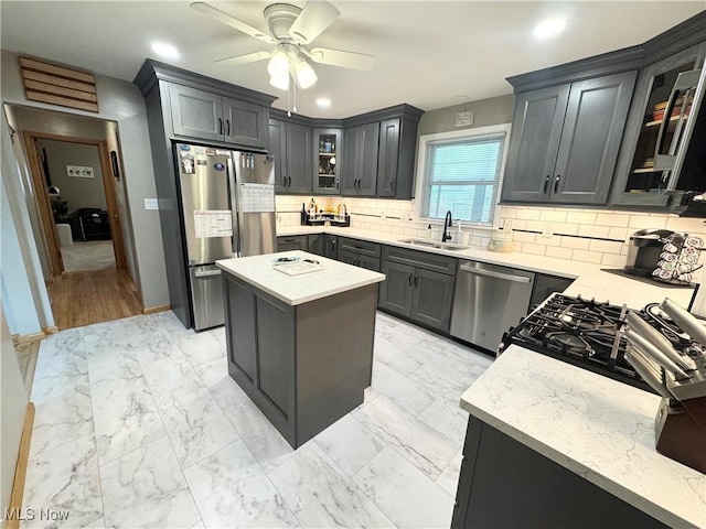 470 Geneva Ave, Struthers, OH 44471 - kitchen with stainless steel appliances, a ceiling fan, light stone counters, decorative backsplash, and a center island