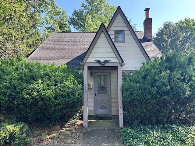 7742 Dahlia Dr, Mentor On The Lake, OH 44060 - view of front of property with a shingled roof and a chimney