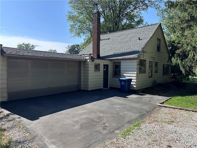 7742 Dahlia Dr, Mentor On The Lake, OH 44060 - view of front of house with a chimney, roof with shingles, a garage, and driveway
