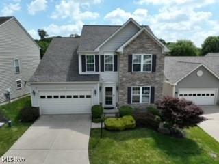 933 Alder Run Way, Akron, OH 44333 - traditional-style house with driveway, stone siding, an attached garage, and a front yard