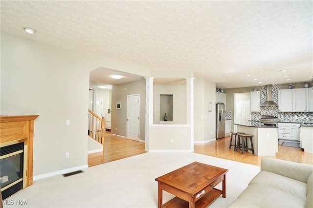933 Alder Run Way, Akron, OH 44333 - living area with a textured ceiling, stairs, a glass covered fireplace, recessed lighting, and light wood finished floors