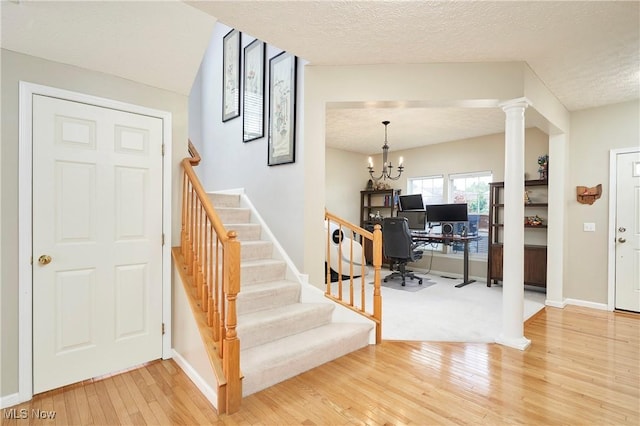 933 Alder Run Way, Akron, OH 44333 - stairway featuring hardwood / wood-style floors, decorative columns, a textured ceiling, and a chandelier