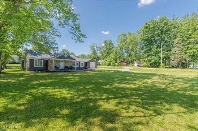 3316 Wadsworth Rd, Norton, OH 44203 - view of grassy yard featuring a porch and an attached garage