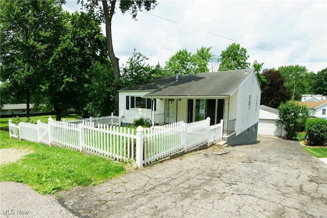 171 W Hiram St, Barberton, OH 44203 - bungalow-style home featuring covered porch, a fenced front yard, an outdoor structure, a detached garage, and roof with shingles