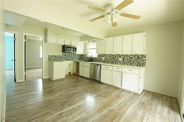 171 W Hiram St, Barberton, OH 44203 - kitchen with stainless steel appliances, white cabinetry, decorative backsplash, a ceiling fan, and light countertops