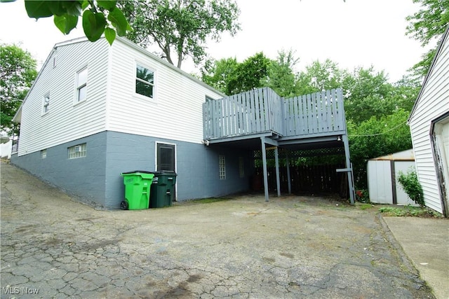 171 W Hiram St, Barberton, OH 44203 - back of property featuring a storage shed, asphalt driveway, a carport, and a deck
