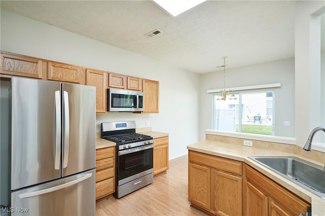 1435 Durham Dr, Broadview Heights, OH 44147 - kitchen featuring stainless steel appliances, light countertops, light wood-type flooring, pendant lighting, and a textured ceiling