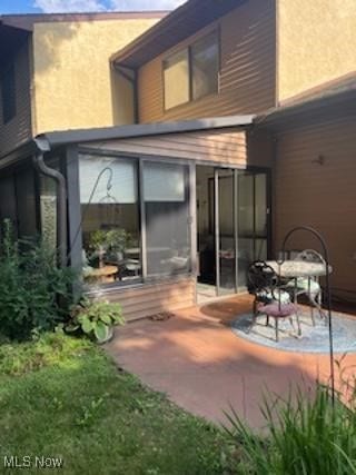 82 Silver Valley Blvd, Munroe Falls, OH 44262 - back of property with a sunroom, a patio area, and stucco siding