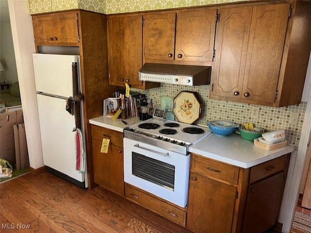 5898 Kellar Rd, New Franklin, OH 44319 - kitchen featuring white appliances, custom exhaust hood, dark wood-style flooring, light countertops, and brown cabinetry