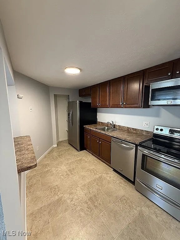 9630 Cove Dr Unit A14, North Royalton, OH 44133 - kitchen featuring appliances with stainless steel finishes, dark brown cabinetry, and dark countertops