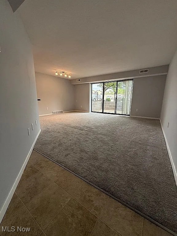 9630 Cove Dr Unit A14, North Royalton, OH 44133 - carpeted empty room with baseboards and tile patterned flooring