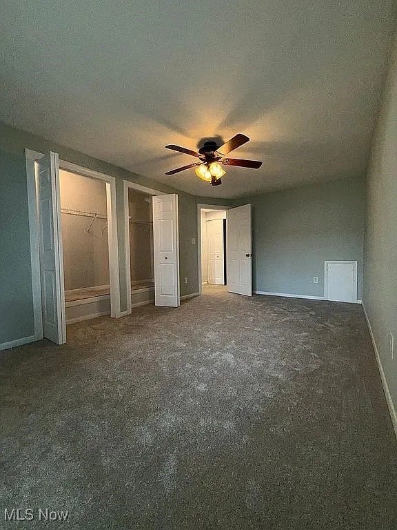 9630 Cove Dr Unit A14, North Royalton, OH 44133 - unfurnished bedroom with carpet, two closets, a ceiling fan, and a textured ceiling