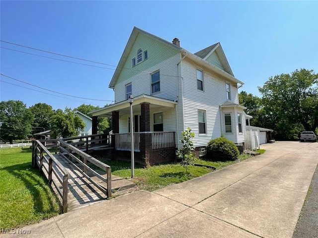4034 Broadway Ave NE, Louisville, OH 44641 - view of front of house with covered porch, a chimney, a detached garage, and a front yard