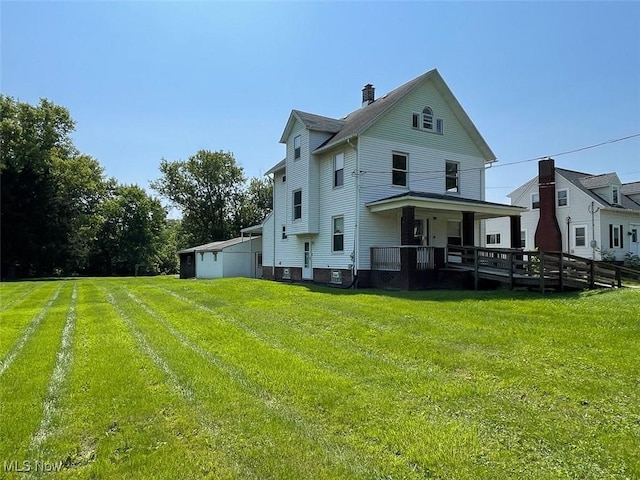 4034 Broadway Ave NE, Louisville, OH 44641 - back of house with a lawn, a chimney, and covered porch