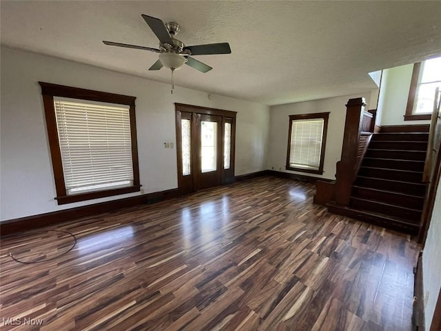 4034 Broadway Ave NE, Louisville, OH 44641 - unfurnished living room featuring dark wood-type flooring, stairs, ceiling fan, and a textured ceiling