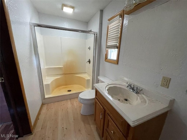 4034 Broadway Ave NE, Louisville, OH 44641 - full bath featuring wood finished floors, a stall shower, vanity, and a textured wall