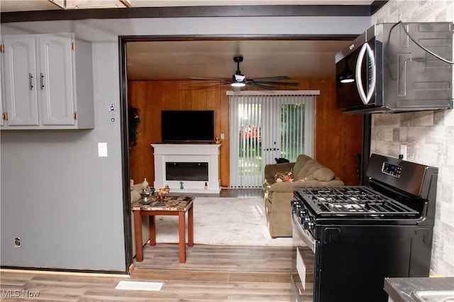 1863 Deerfield Ave SW, Warren, OH 44485 - kitchen with stainless steel appliances, a ceiling fan, light wood-style floors, and white cabinets