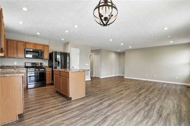 107 Lakeview Cir, Amherst, OH 44001 - kitchen featuring appliances with stainless steel finishes, recessed lighting, a kitchen island, dark wood finished floors, and a chandelier