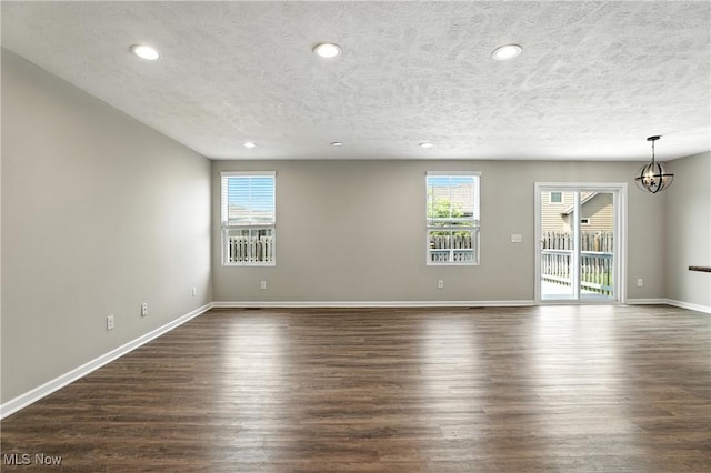 107 Lakeview Cir, Amherst, OH 44001 - empty room featuring a chandelier, dark wood finished floors, a textured ceiling, and recessed lighting