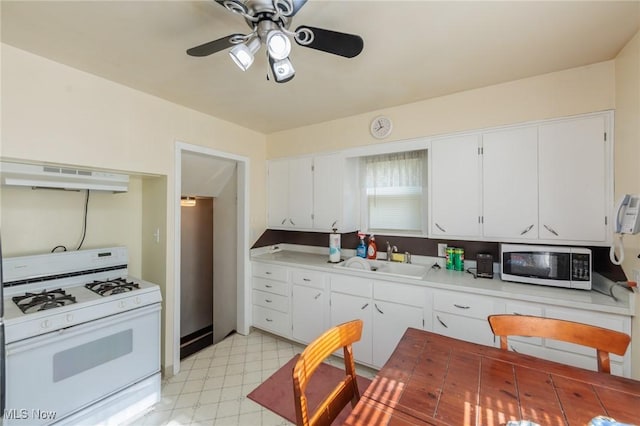 4766 Brookwood Dr, Brooklyn, OH 44144 - kitchen with white gas range, ventilation hood, light flooring, ceiling fan, and light countertops