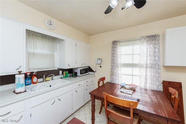 4766 Brookwood Dr, Brooklyn, OH 44144 - kitchen featuring white microwave, light countertops, ceiling fan, white cabinets, and light floors