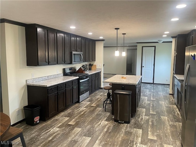 83478 Monzula Rd, Cadiz, OH 43907 - kitchen featuring appliances with stainless steel finishes, dark wood-type flooring, a center island, recessed lighting, and a kitchen bar