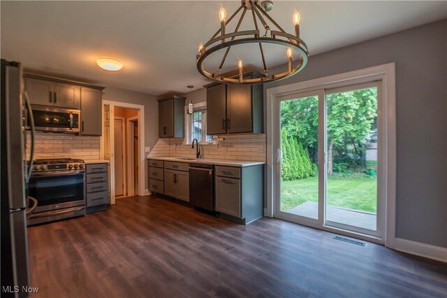 216 W Glenridge Rd, Green, OH 44319 - kitchen with stainless steel appliances, light countertops, backsplash, a chandelier, and dark wood-type flooring