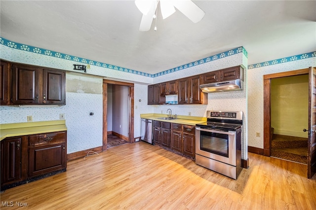 13778 Spring St, Burton, OH 44021 - kitchen with appliances with stainless steel finishes, wallpapered walls, under cabinet range hood, light wood-type flooring, and dark brown cabinetry