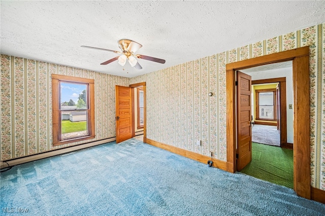 13778 Spring St, Burton, OH 44021 - carpeted spare room featuring baseboard heating, a textured ceiling, wallpapered walls, and ceiling fan