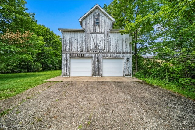 13778 Spring St, Burton, OH 44021 - view of front of house featuring a detached garage and a front lawn