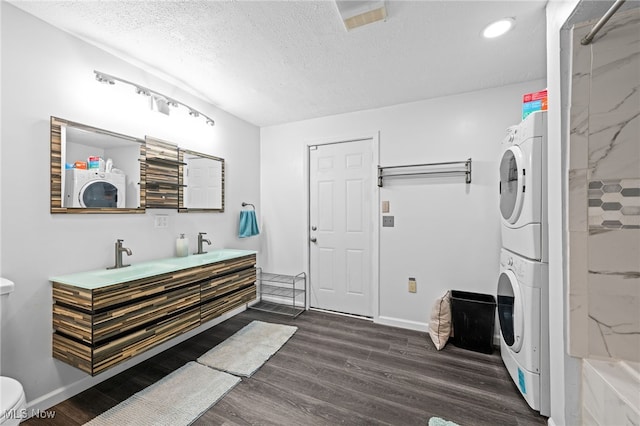 8902 Taylor May Rd, Chagrin Falls, OH 44023 - bathroom with stacked washer / drying machine, wood finished floors, double vanity, a textured ceiling, and a shower