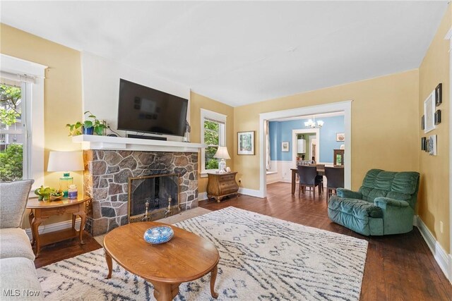 1901 Newton St, Akron, OH 44305 - living room featuring healthy amount of natural light, a chandelier, wood finished floors, and a stone fireplace