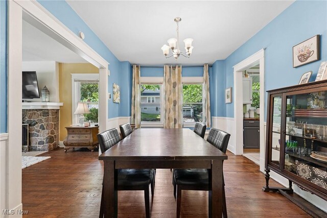 1901 Newton St, Akron, OH 44305 - dining room featuring a chandelier, healthy amount of natural light, wainscoting, wood finished floors, and a stone fireplace