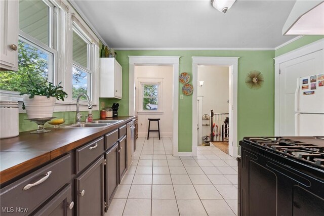 1901 Newton St, Akron, OH 44305 - kitchen featuring black gas range, light tile patterned floors, crown molding, stainless steel dishwasher, and wood counters