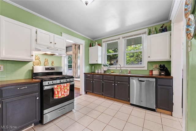 1901 Newton St, Akron, OH 44305 - kitchen with stainless steel appliances, under cabinet range hood, white cabinetry, and ornamental molding