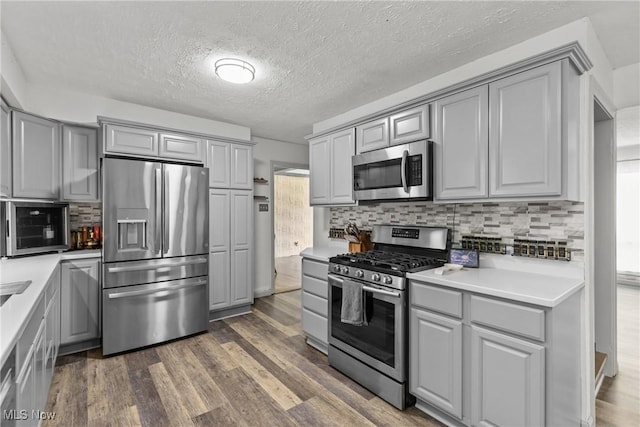 16792 Gonzales Ave, East Liverpool, OH 43920 - kitchen featuring appliances with stainless steel finishes, gray cabinetry, dark wood-style flooring, and a textured ceiling