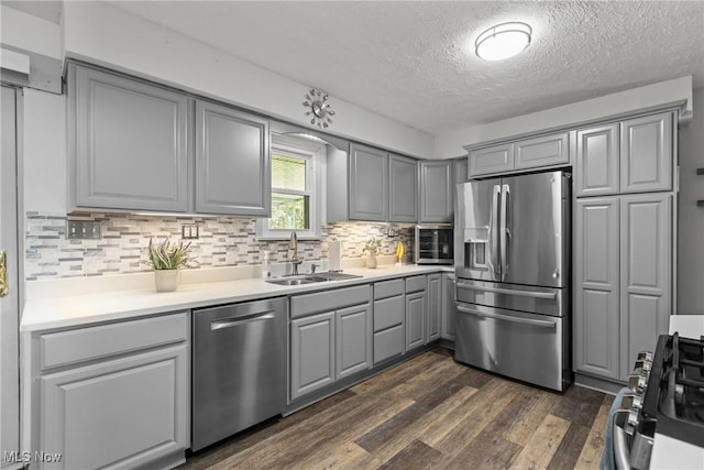16792 Gonzales Ave, East Liverpool, OH 43920 - kitchen with stainless steel appliances, gray cabinetry, a textured ceiling, dark wood-style floors, and tasteful backsplash