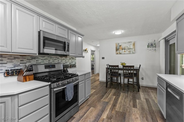 16792 Gonzales Ave, East Liverpool, OH 43920 - kitchen featuring stainless steel appliances, gray cabinetry, dark wood-type flooring, decorative backsplash, and light countertops